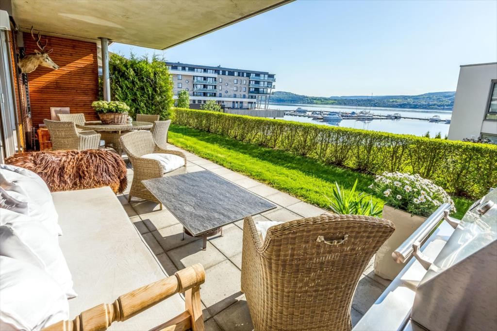 Stor terrasse med et lite plenareale utenfor. Flott utsikt mot fjorden. Galleribilde