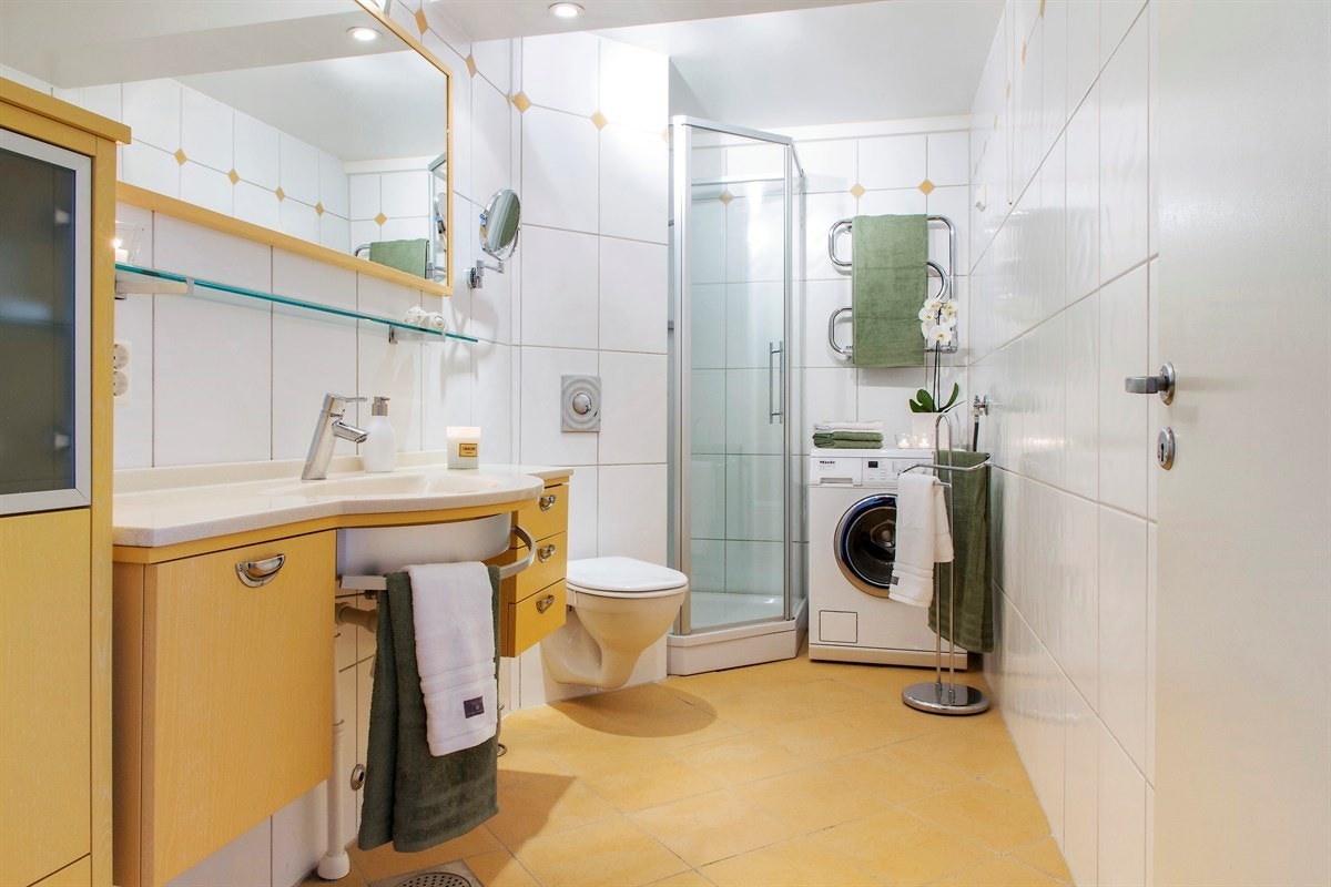 Stor baderom med plass til dusjkabinett og opplegg til vaskemaskin/tørketrommel Galleribilde