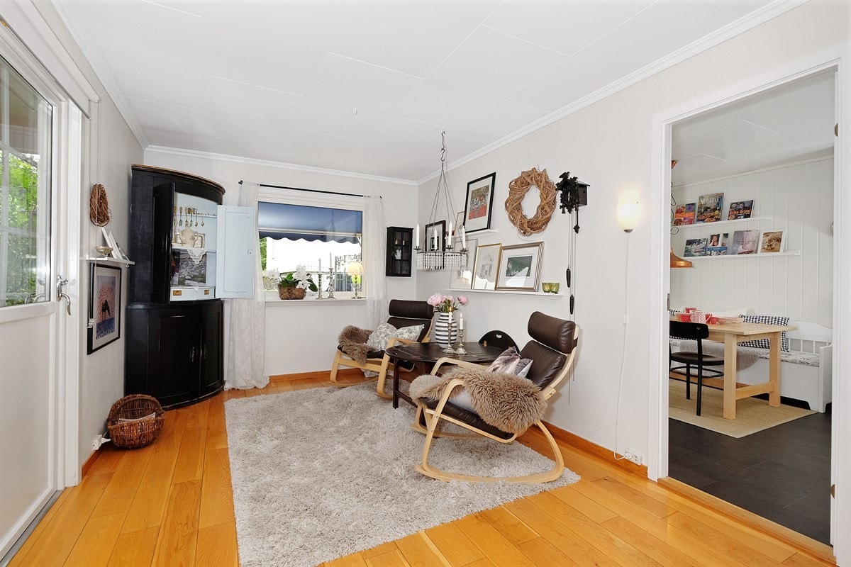 Lys og trivelig stue med parkett på gulvet, lysmalte vegger og tak. Galleribilde