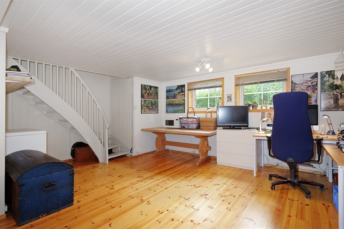 Kjelleren er innredet med kjellerstue hvor man har store vinduer, kontor med lite vindu, bad, verksted og mye bodplass Galleribilde
