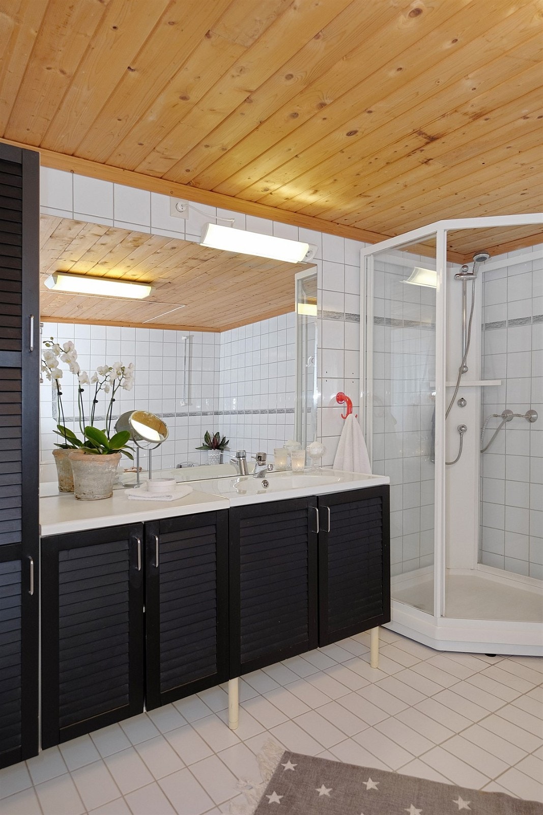 Badet er innredet med badekar, dusjkabinett, baderomsinnredning, wc og opplegg for vaskemaskin Galleribilde