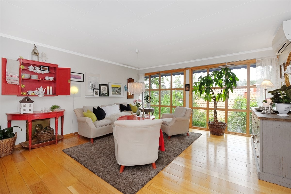 Koselig stue med store vinduer som gir fint lys inn i rommet Galleribilde