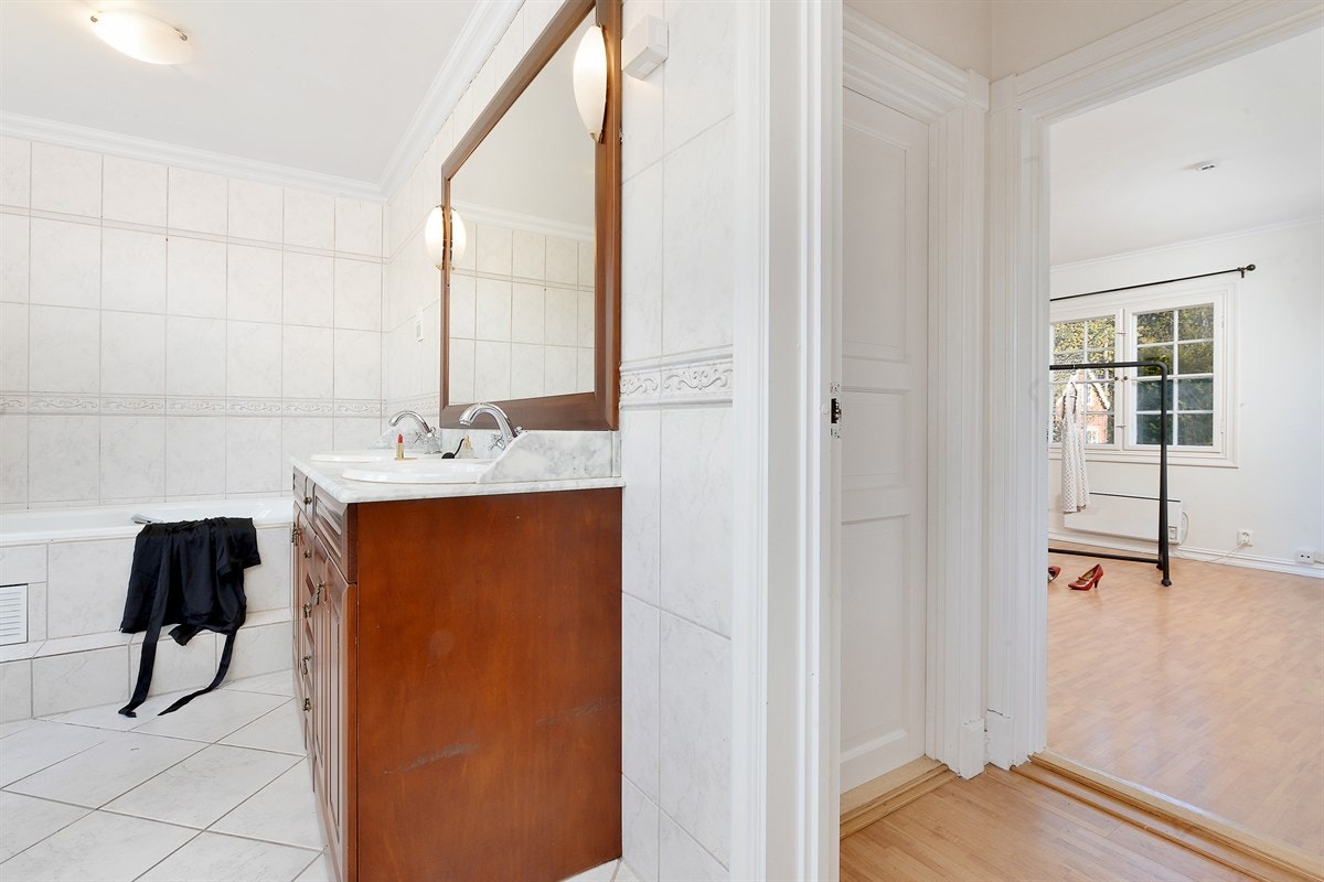 Pent flislagt bad med badekar, dusjnisje, dobbelservant, bidé og wc Galleribilde
