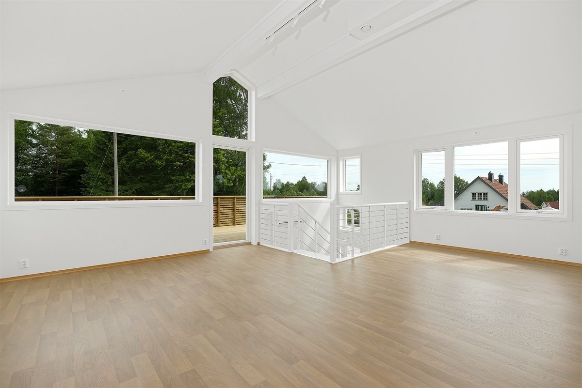 Lyse og moderne gulv skaper et godt første inntrykk når man går opp trappen til stuen og kjøkkenet, rommet har store vindusflater som gir et godt og naturlig lysinnslipp Galleribilde