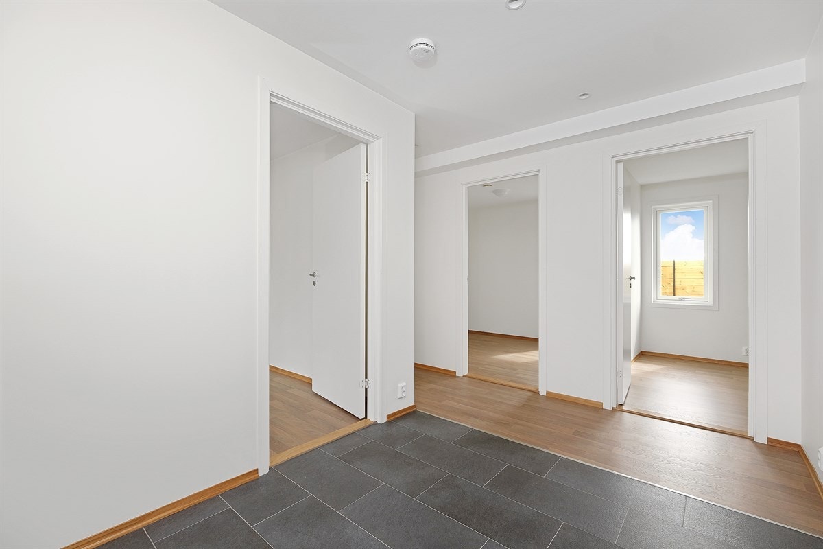 Romslig flislagt entré som gir et godt førsteinntrykk av boligen. Direkte tilgang til bad/vaskrom og boligens tre soverom. I gangen er det plass til en romslig garderobe Galleribilde