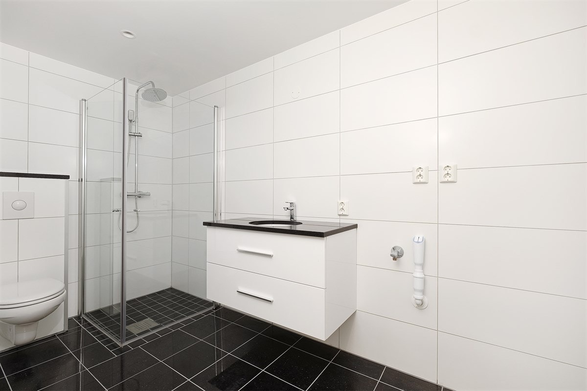 Boligen har to bad. Badene er praktisk plasser med et bad i hver etasje. Begge har servant med praktisk oppbevaring og speil med god belysning, dusjhjørne med glassdører Galleribilde