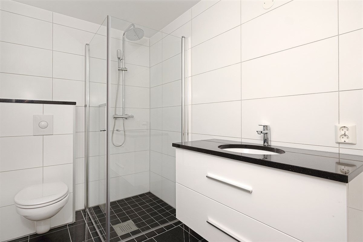 Moderne fliser på gulv og vegger, varme i gulv. (benkeplate og gulvflis = Black Galaxy granitt) Begge badene har opplegg til vaskemaskin Galleribilde