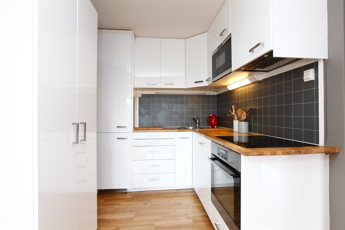 Pen hvit høyglanset kjøkkeninnredning fra 2014 med heltre benkeplate. Galleribilde