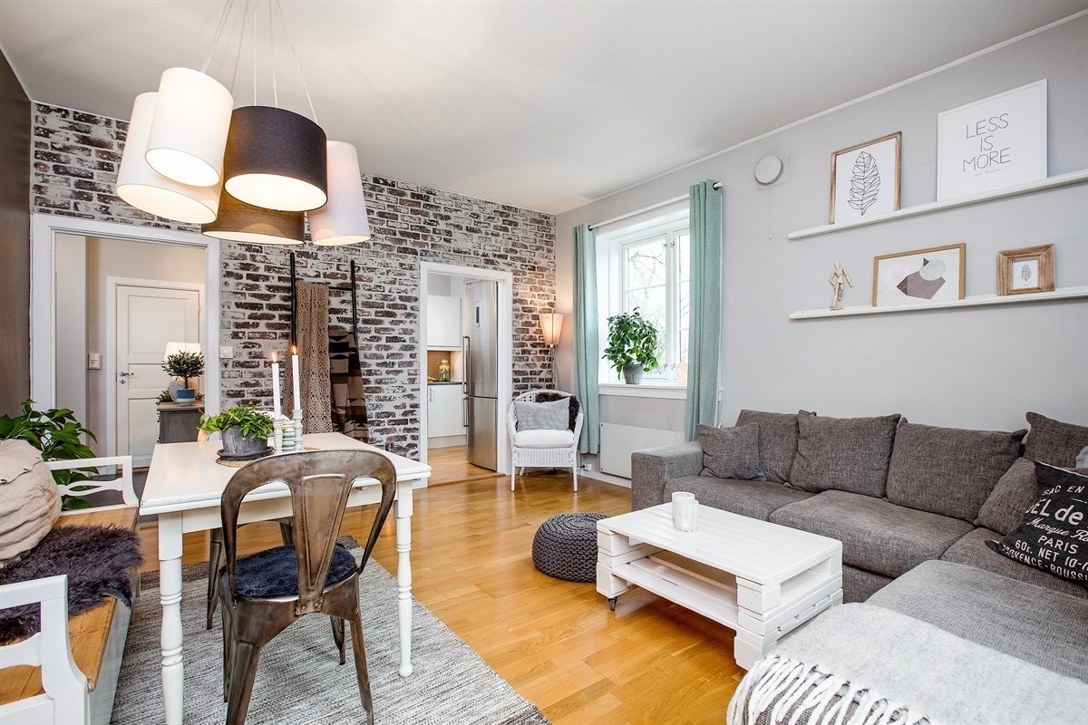 Stor stue med åpning mot kjøkken - peis er montert mellom dør mot gang og dør mot kjøkken etter at bilde ble tatt. Galleribilde