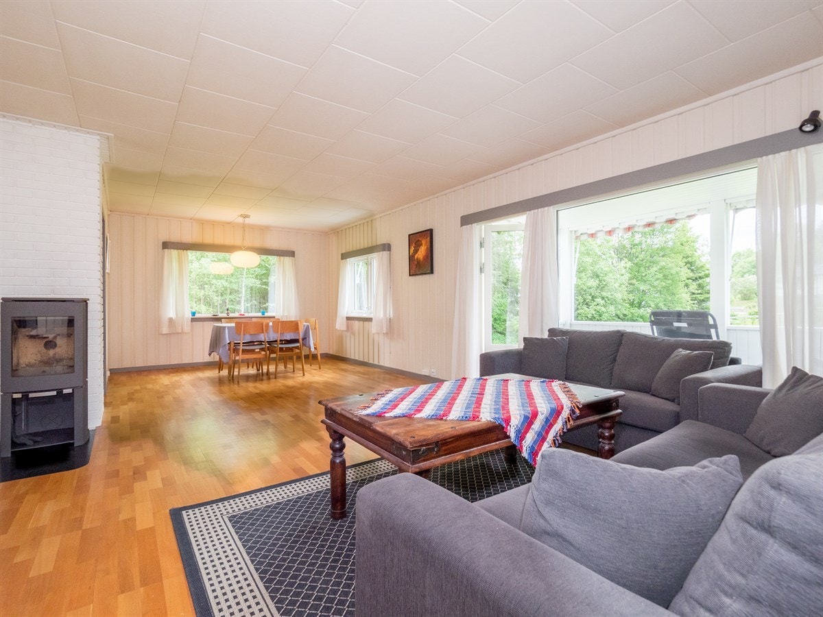 Stue og spisestue i ett og samme rom, med en delikat vedovn fra 2012. Galleribilde