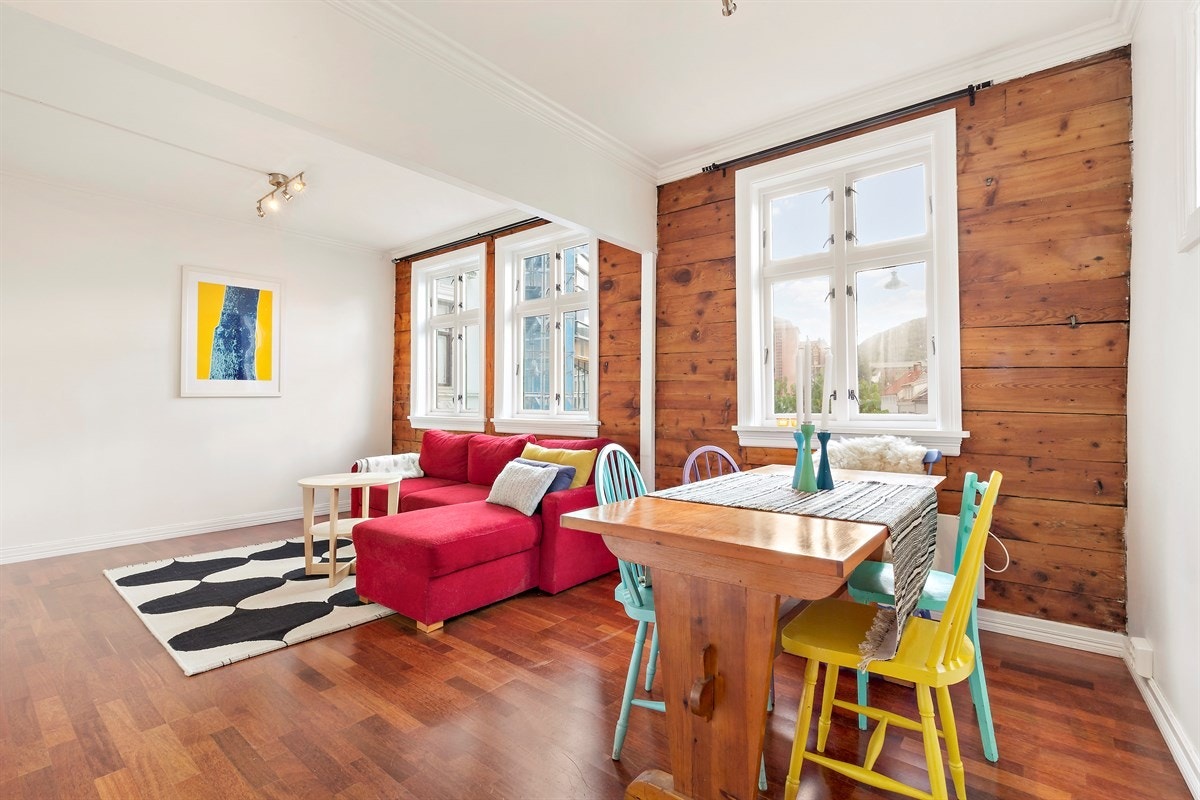 3 stavs merbau parkett på gulvet mot laftet plank og lysmalte overflater på vegger. Galleribilde