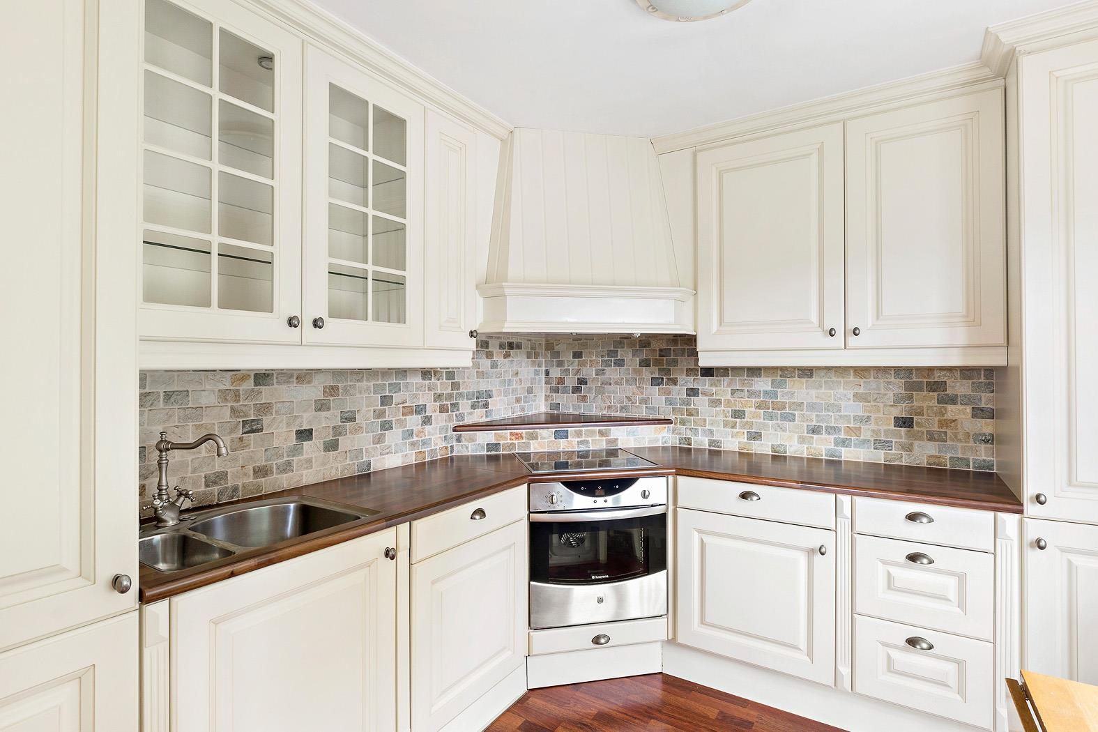 Nyare kjøkkeninnreiing med takhøge skap og integrerte kvitevarer. Galleribilde