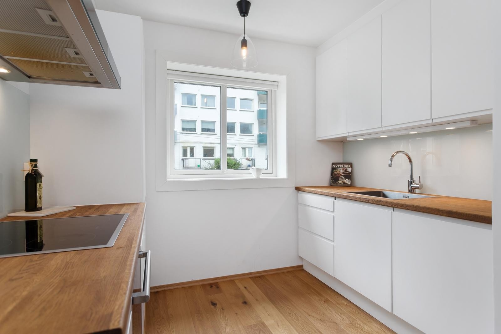 Integrerte hvitevarer inkluderer stekeovn med platetopp, oppvaskmaskin, og kjøleskap. Galleribilde