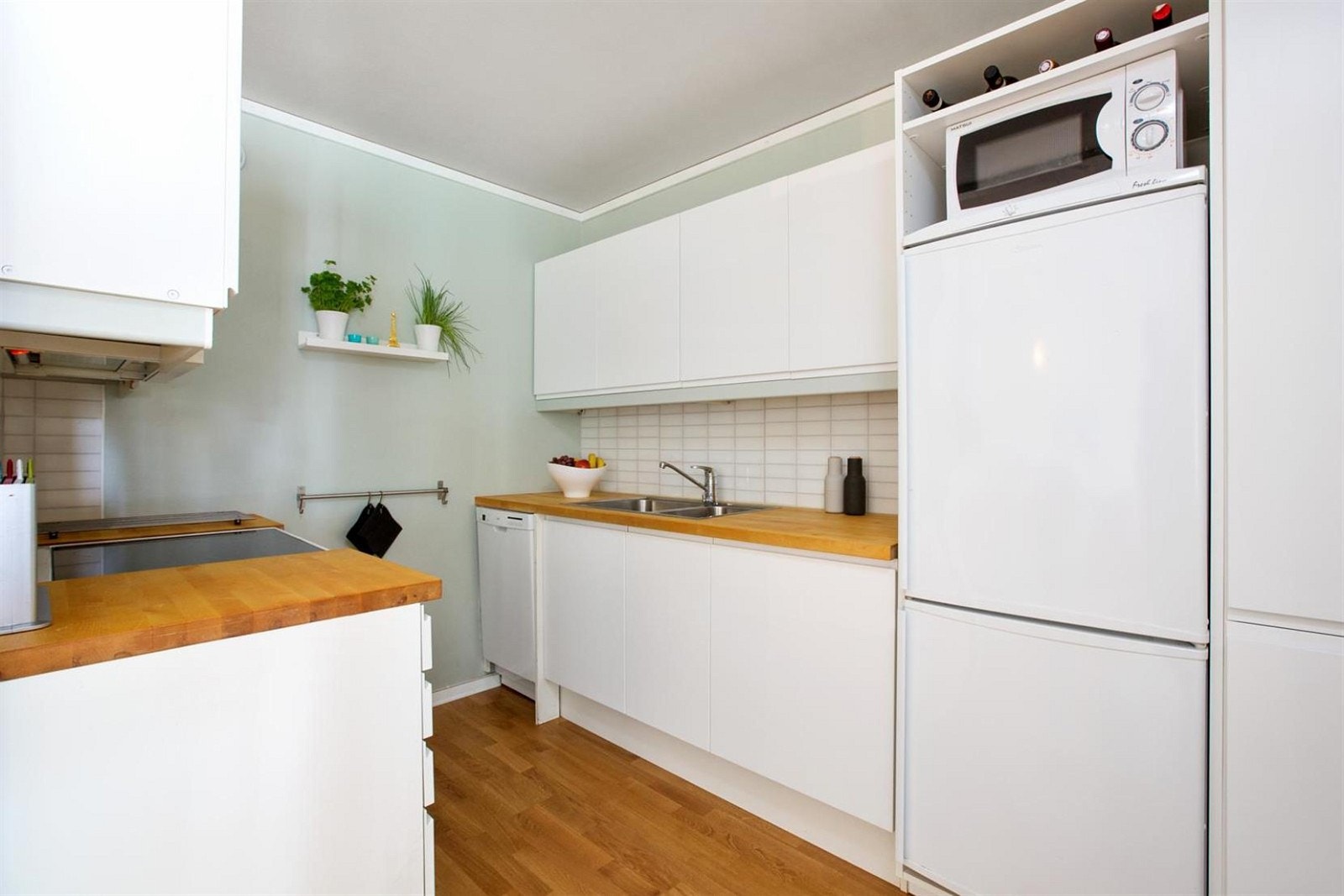 Kjøkkeninnredning med glatte malte fronter. Bøk benkeplater med nedfelt rustfritt beslag med to
kummer. Laminat plater, dekket med plast over benk. Opplegg oppvaskmaskin. Galleribilde