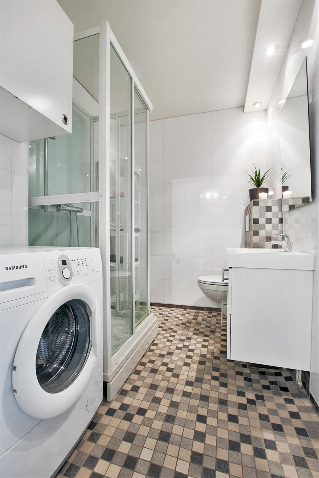 Pent bad/wc/vaskerom med dusjkabinett. Veggmontert wc, servantinnredning med heldekkende servant. Varmekabler på gulv. Galleribilde