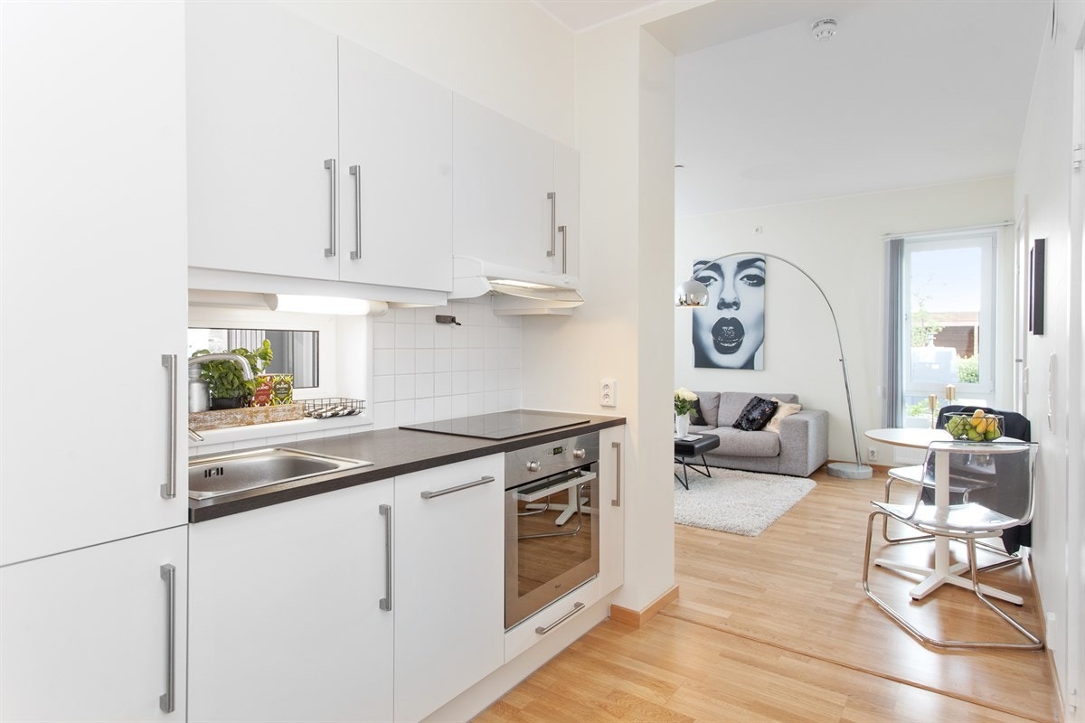 Kjøkkenet er plassert langs veggen mellom gang og stue, noe som gjør det meget arealeffektivt. Galleribilde