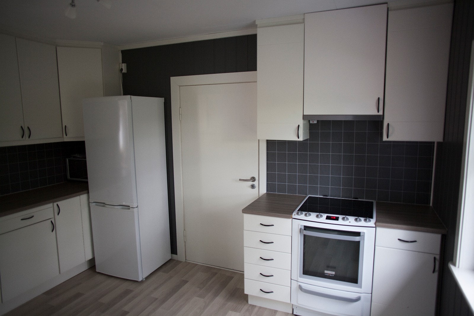 Kjøkken med kjøleskap, oppvaskmaskin, komfyr, mikro og vaskemaskin. Galleribilde