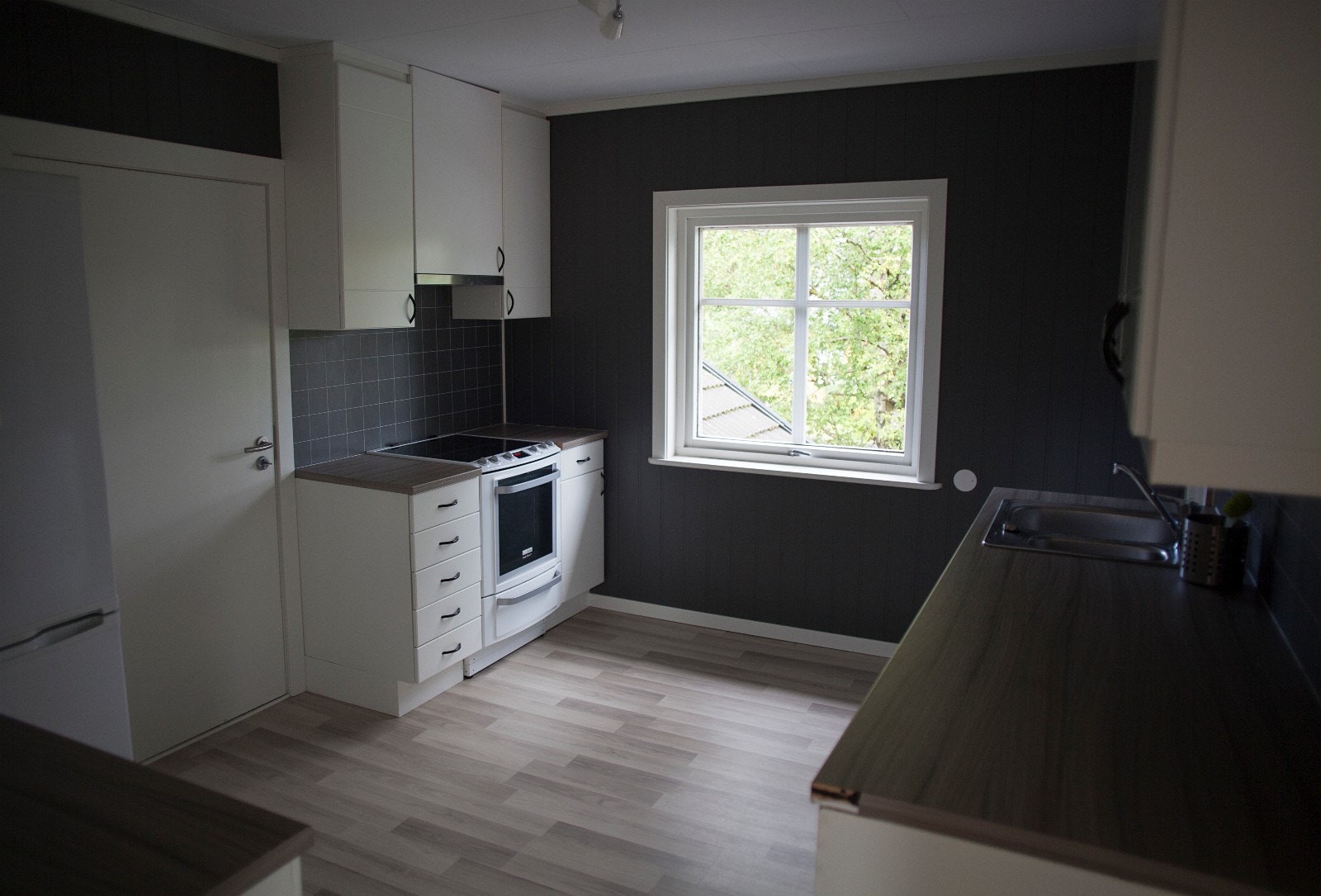 Kjøkken med kjøleskap, oppvaskmaskin, komfyr, mikro og vaskemaskin. Galleribilde