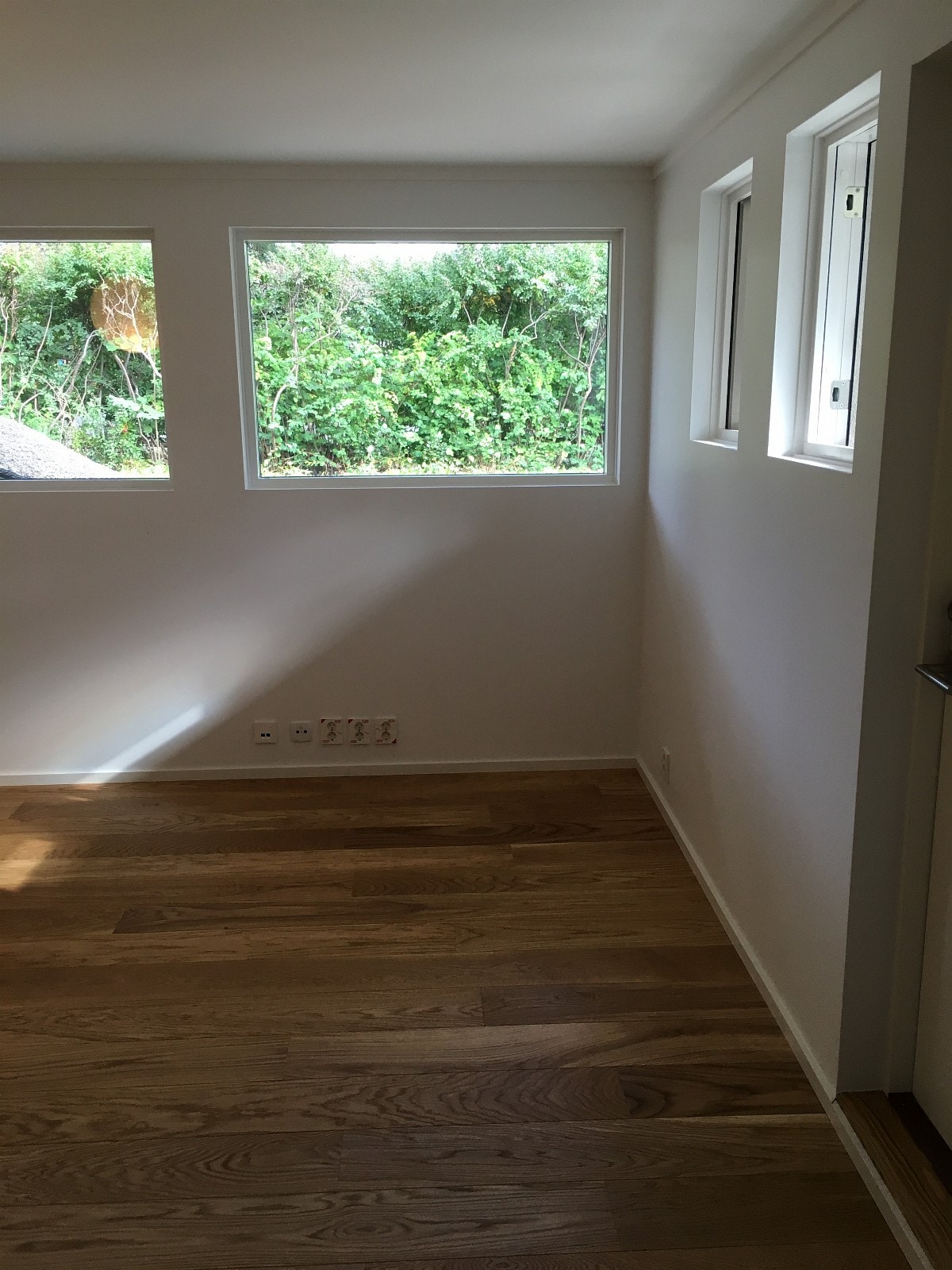 Store vinduer ut mot hage. Persienner montert Galleribilde