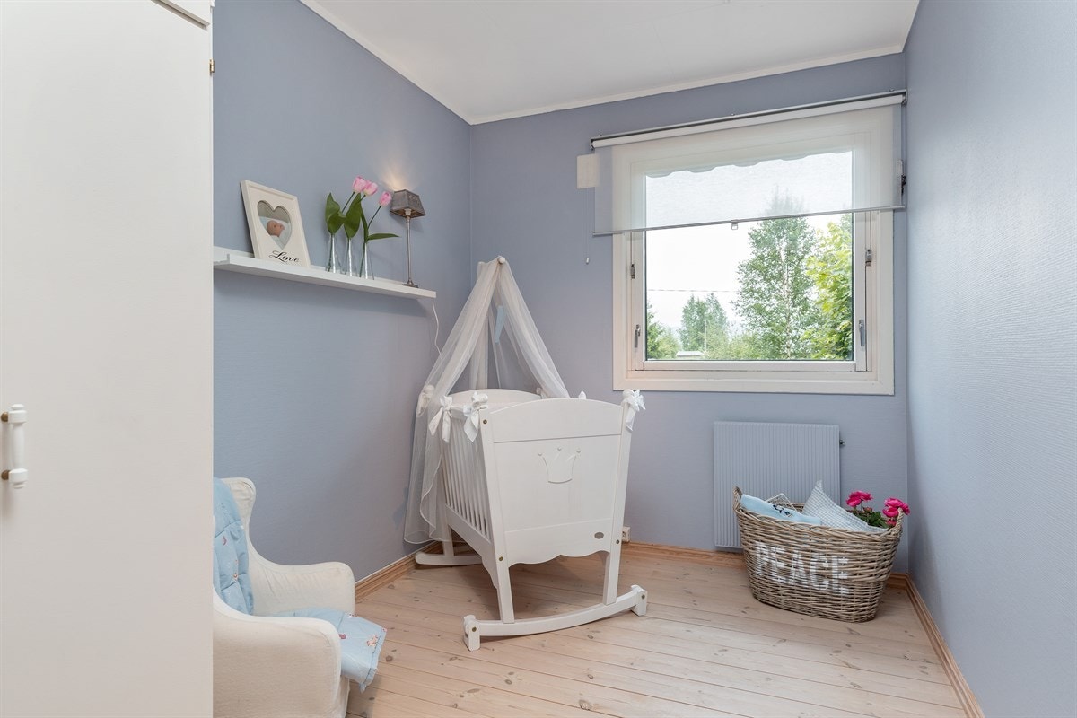 Soverom 2 fremstår som det ultimate barnerom. Her er det malte overflater i en delikat lys blåfarge og heltre gulvbord i furu. Nydelig utsyn fra vinduet over eiendommen. Galleribilde