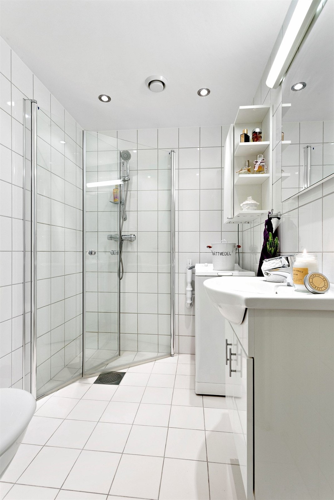 Badeværelset er delikat innredet med lyse moderne fliser og opplegg for vaskemaskin. Galleribilde