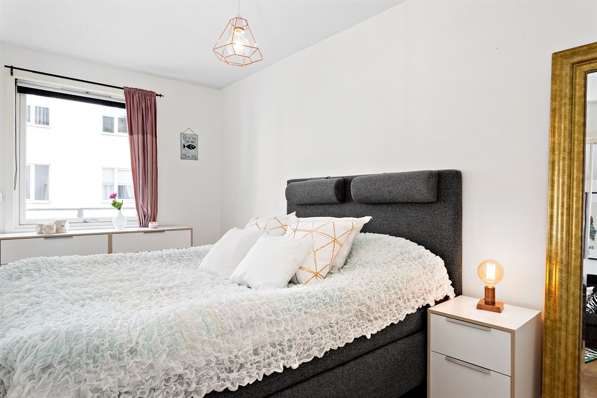 Soverommet har lyse flater og et stort vindu som slipper inn rikelig med naturlig sollys Galleribilde