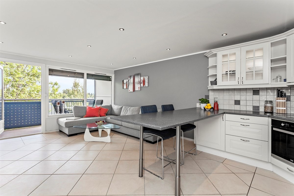 De store vindusflatene, lyse materialvalg og spotter i taket gir en lett og delikat stue. Galleribilde