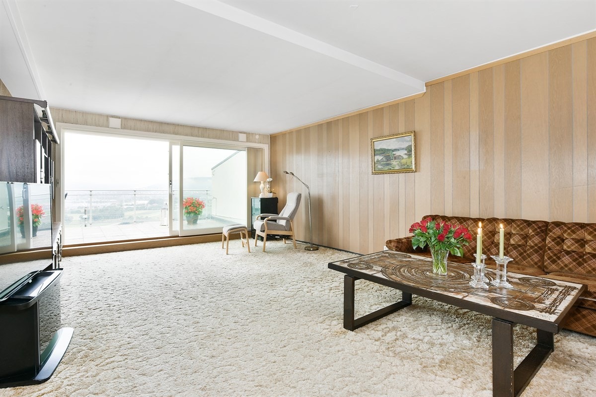 Gulvet har vegg-til-vegg teppe og på veggene er det hovedsakelig panelplater. Galleribilde