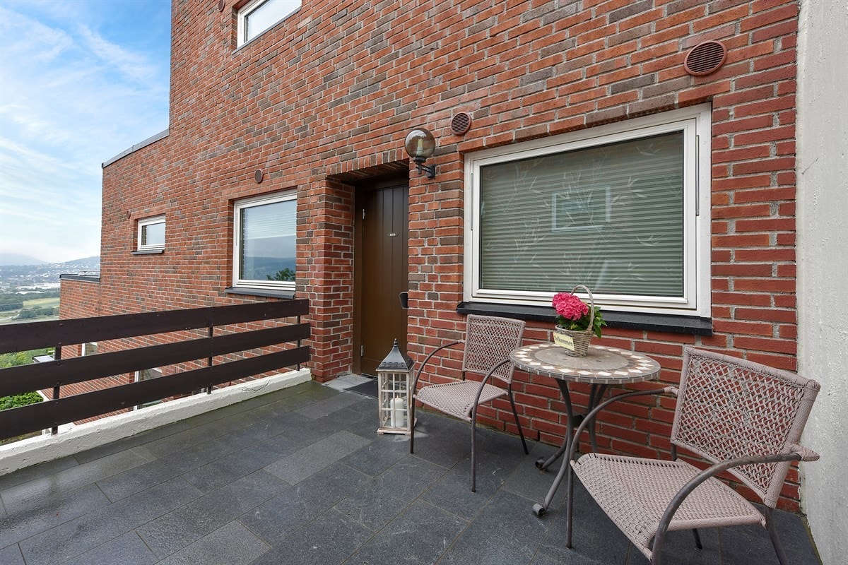 Boligen har adkomst fra felles utvendige trapper og plass for sittegruppe ved inngangspartiet. Galleribilde