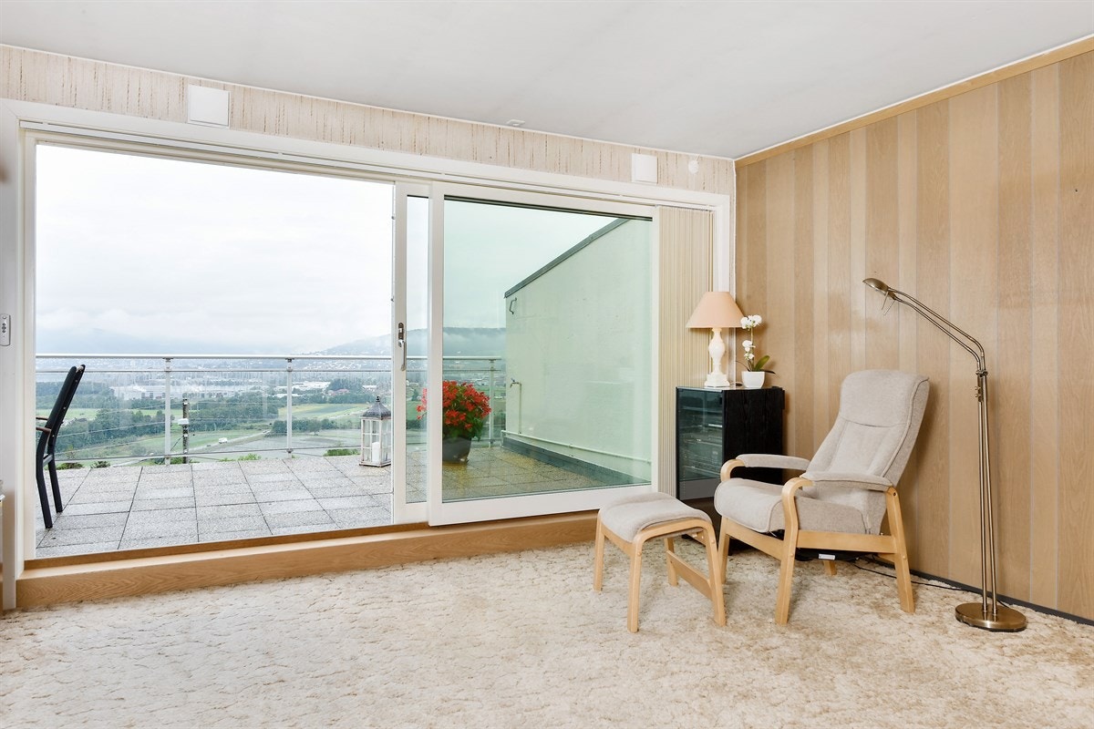 Stuen har skyvedører med generøse vinduer som leder ut til terrasse, og på mesterlig vis ivaretar en storlått utsikt. Galleribilde