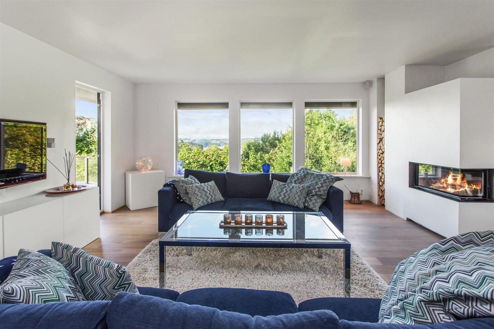 Romslig stue i hovedetasjen med store utsiktsvinduer og utgang til terrasse Galleribilde