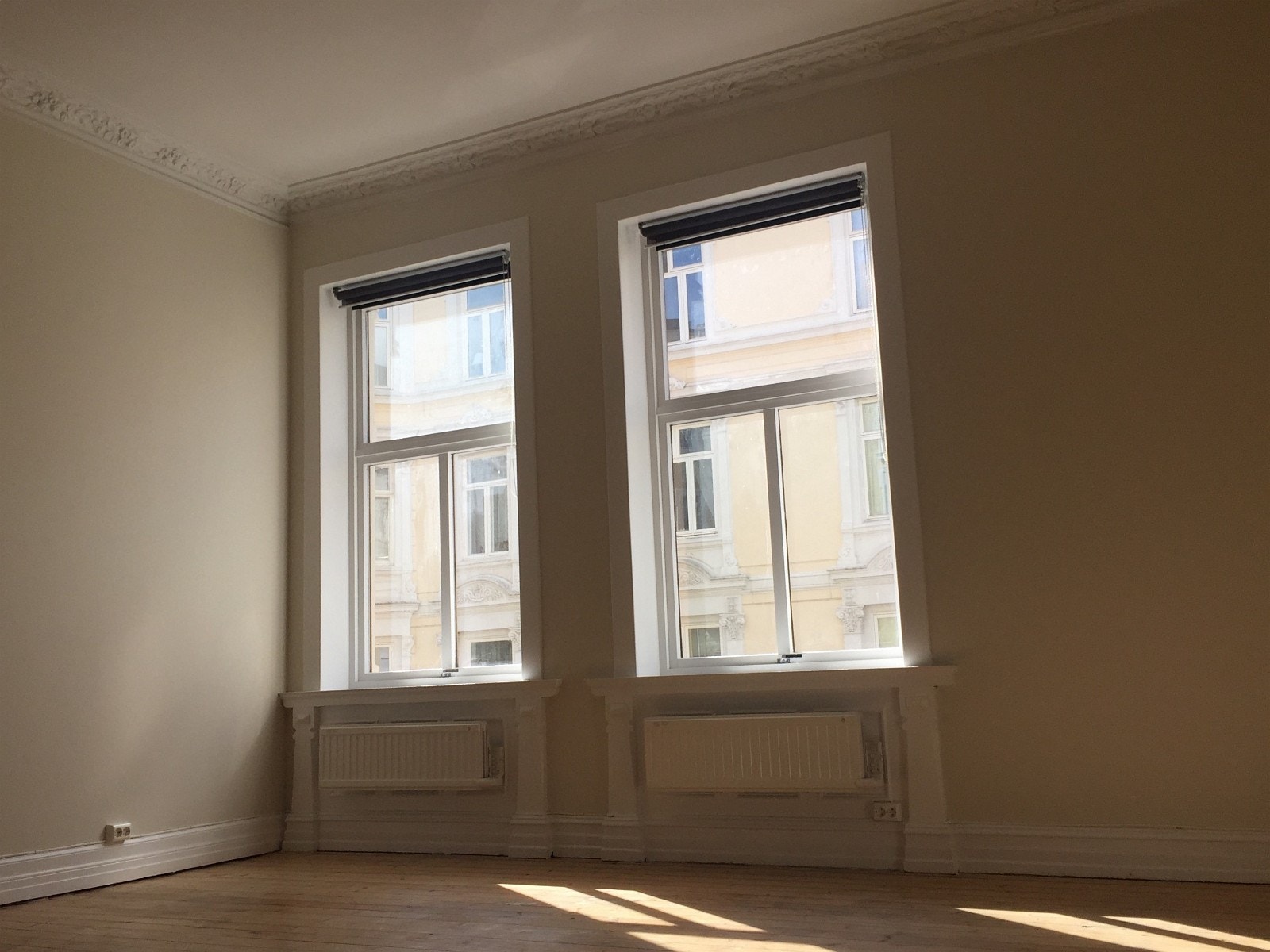 To vinduer på stue, samt to varmeovner. Galleribilde