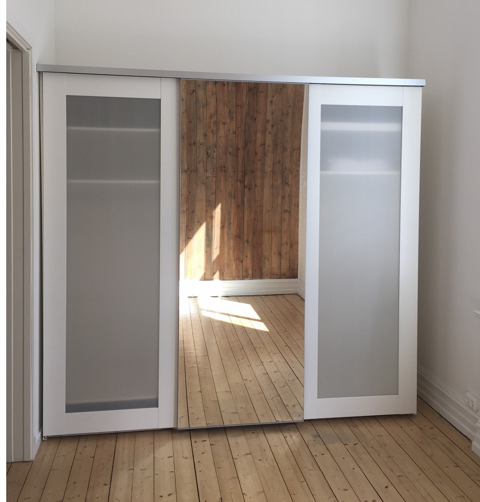 Stort trippelskap hvor den ene skyvedøren er et "helspeil". Galleribilde