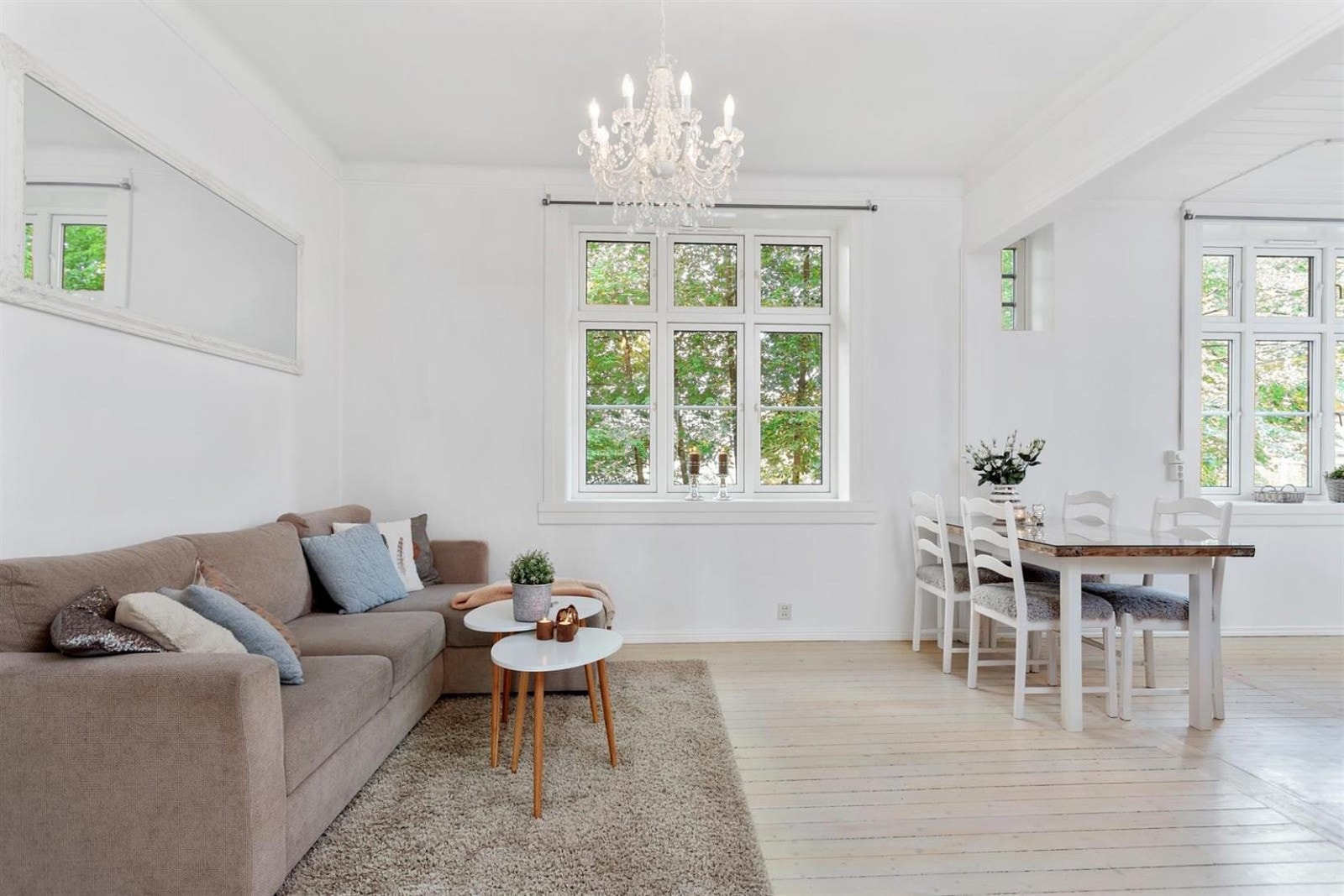 Takhøyden i stuen er på ca. 3,20m, og med store vinduer blir atmosfæren svært lys og luftig. Plass til både stor sofagruppe og spisebord til venner og familie i stuen. Galleribilde