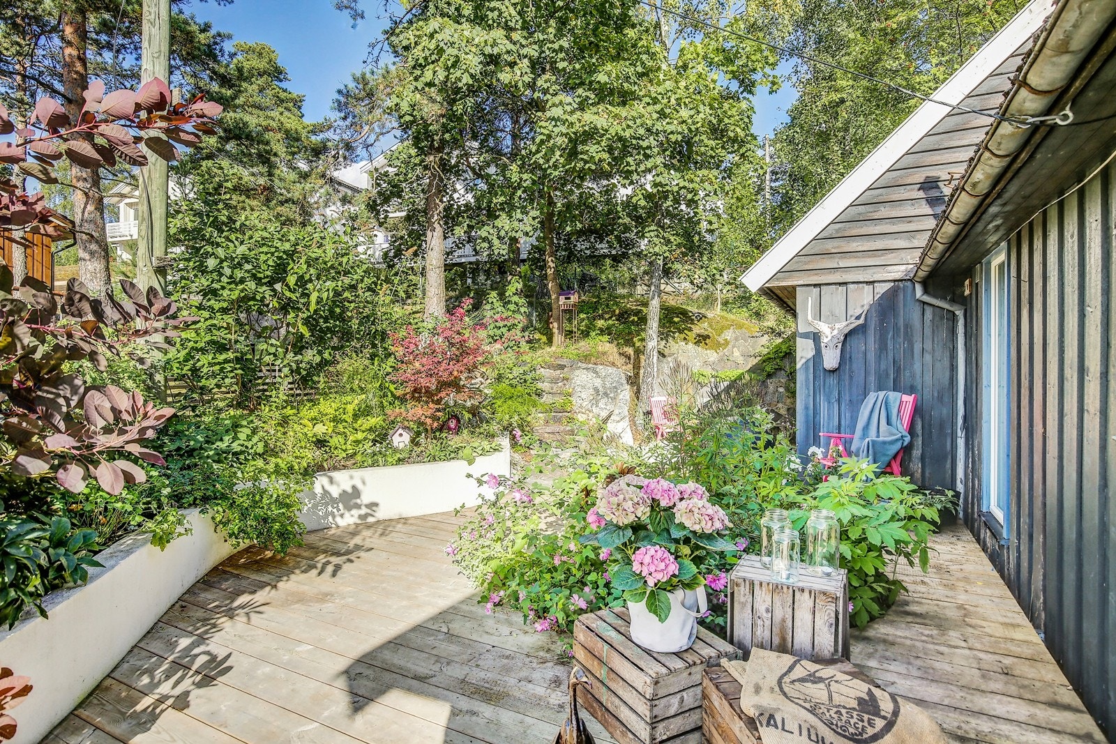Terrassen går rundt huset og leder til naturtomten mot øst. Galleribilde