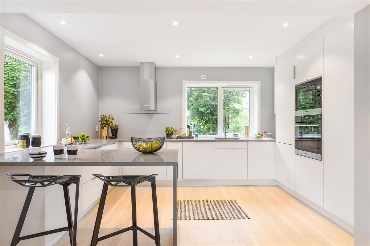 Kjøkkenet ligger åpent mot stuen, adskilt av en stilig barløsning med sitteplasser. Innredningen er fra HTH og fremstår som både velutstyrt og svært stilren. Galleribilde