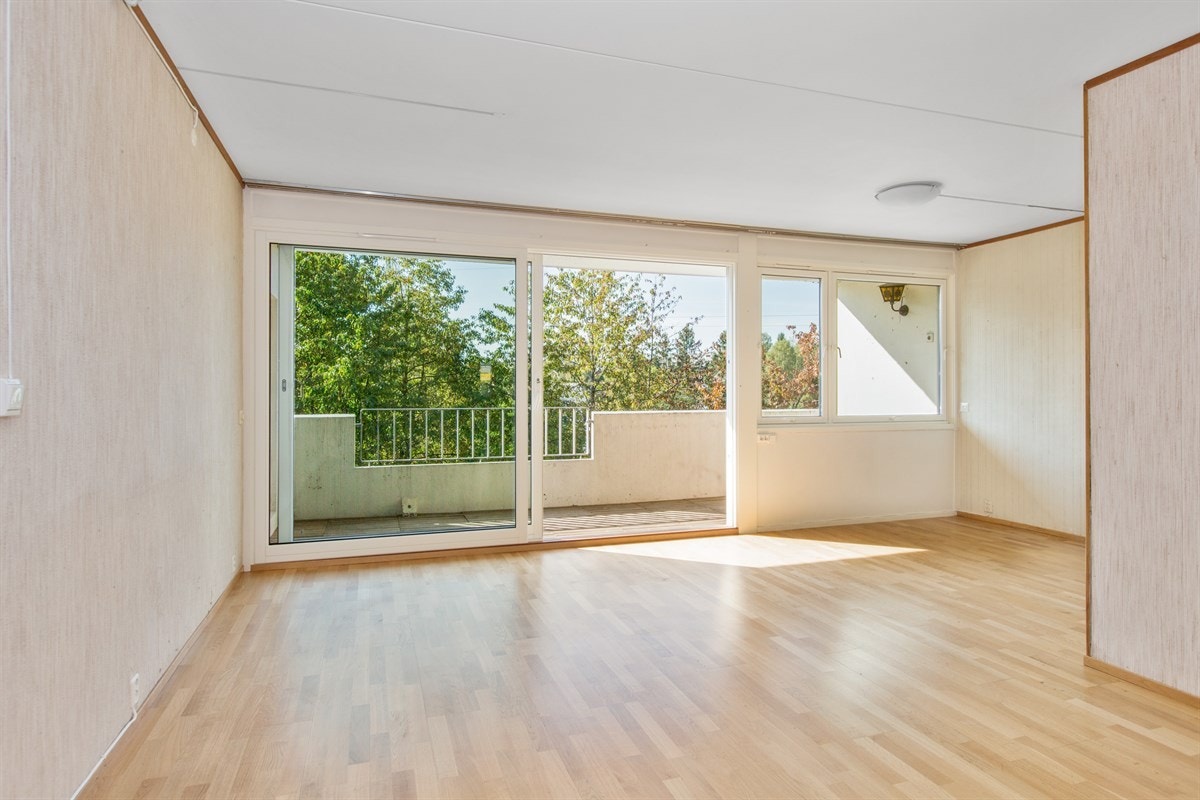 Lys og trivelig stue med stor takhøy skyvedør ut mot solrik usjenert balkong. Galleribilde