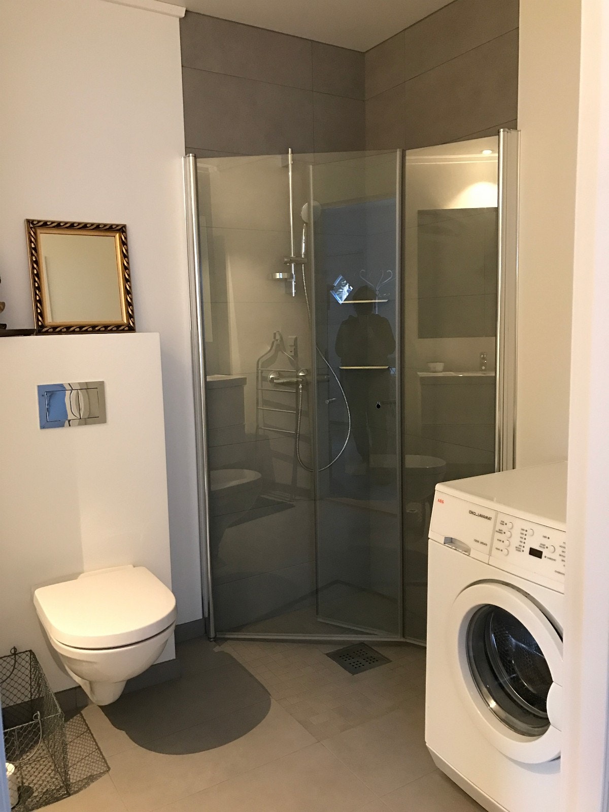 Bad med dusjhjørne og vaskemaskin Galleribilde