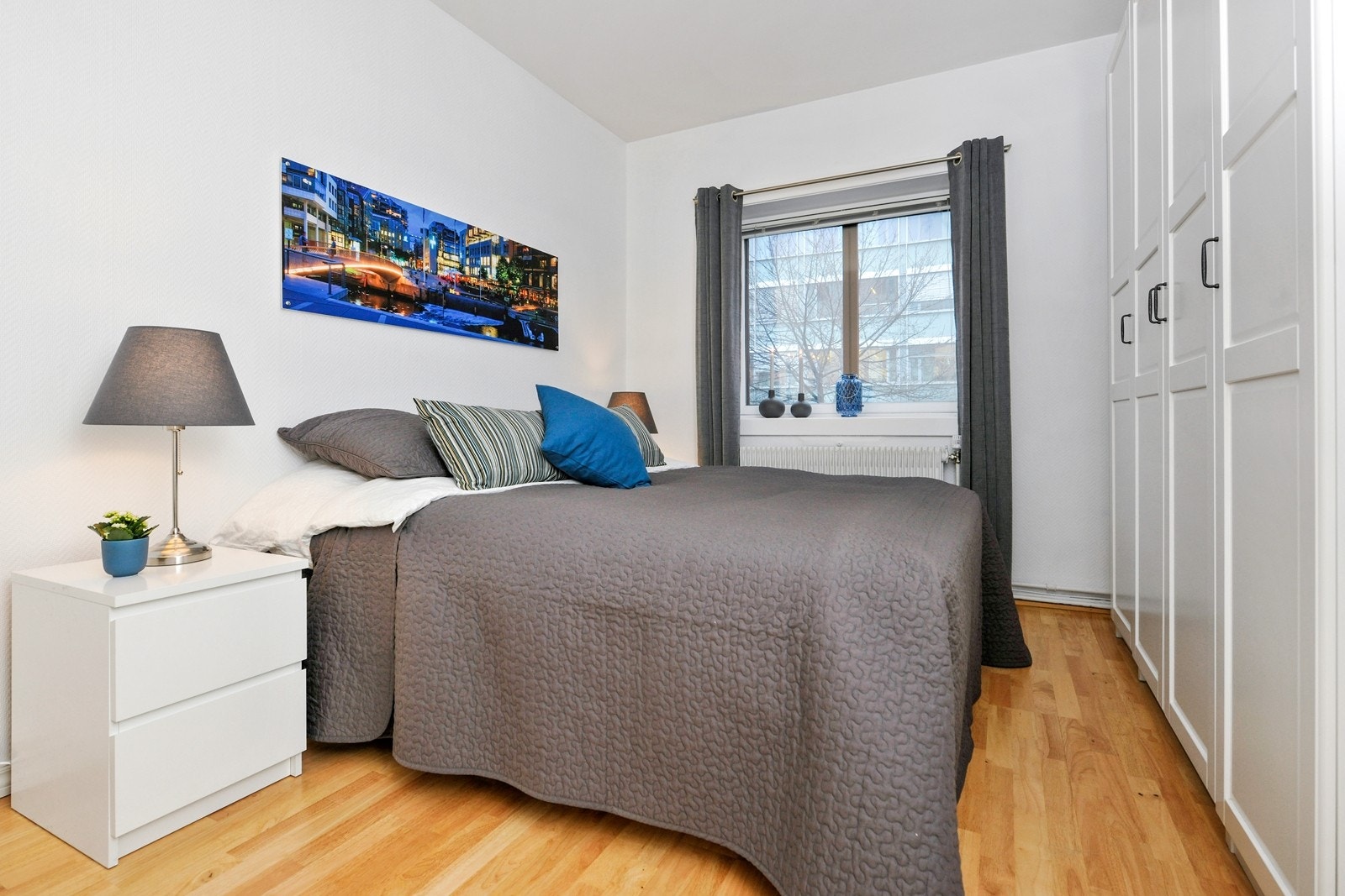 Lyst og romslig soverom med masse garderobeplass i skaprekke langs en hel vegg Galleribilde