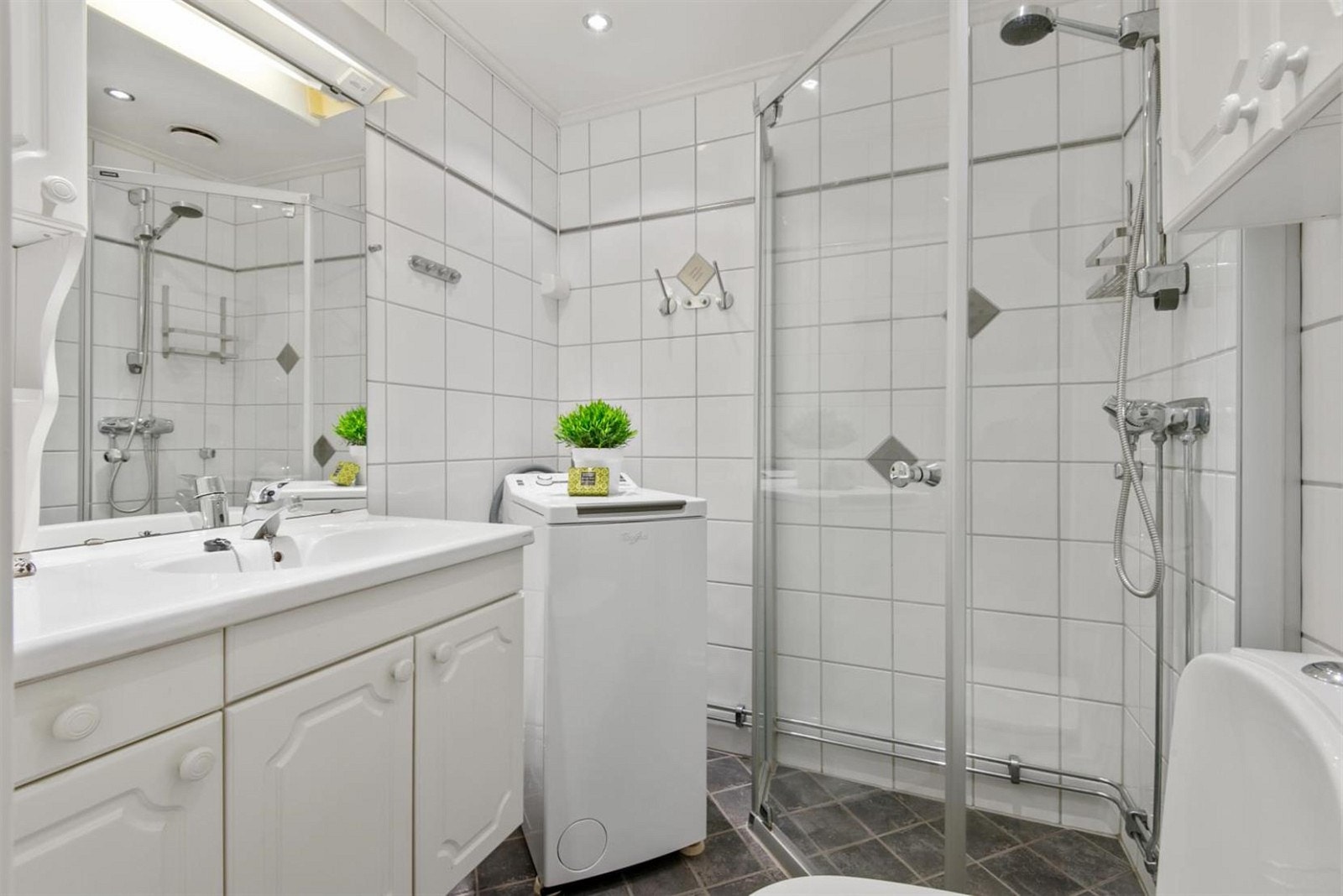 Helflislagt bad med varmekabler i gulv og downlights i tak. Opplegg for vaskemaskin. Galleribilde