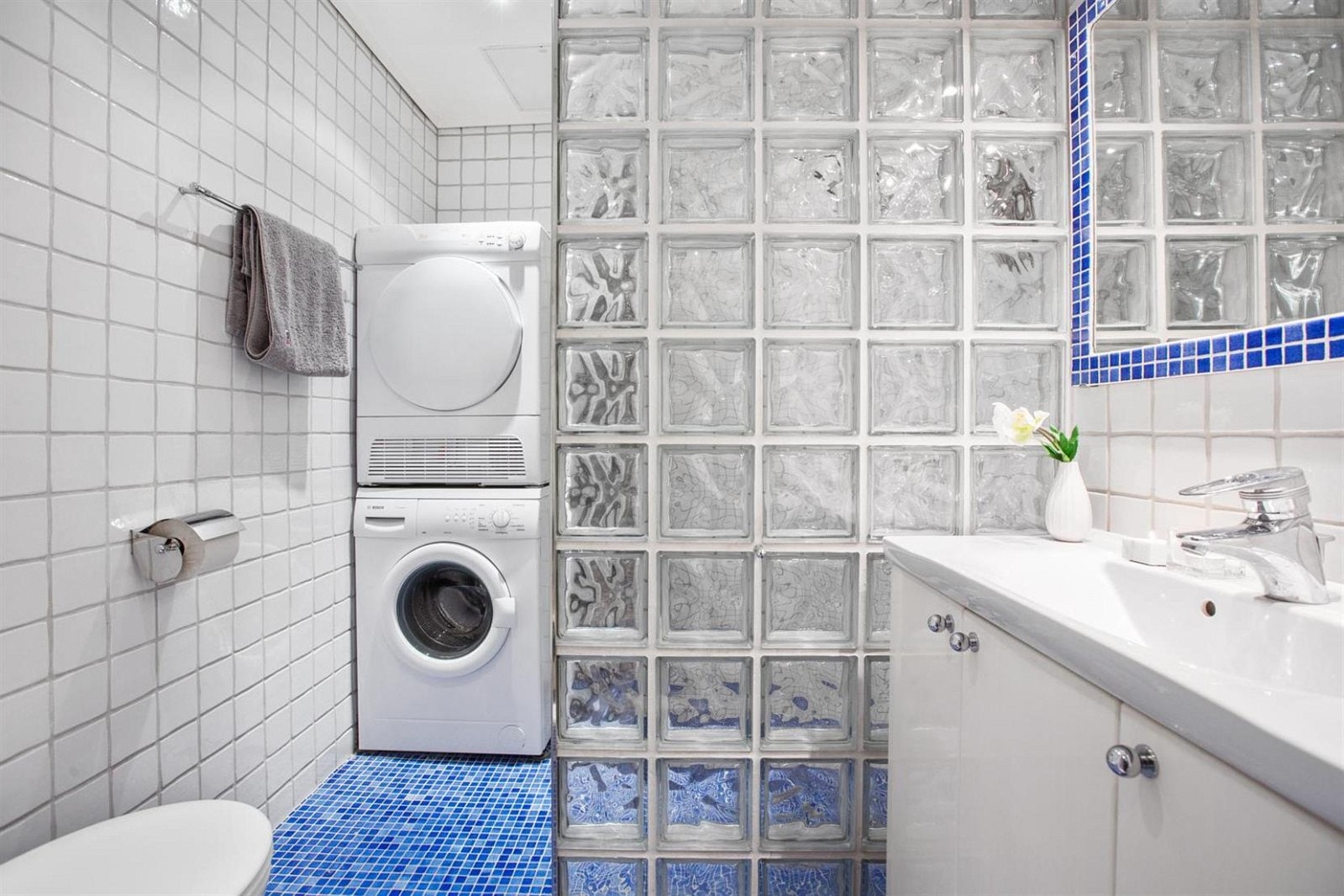 Bad/Wc med gulvstående toalett, 90 cm servant med underskap, dusjhjørne med vegger i glassbyggerstein. Opplegg for vaskemaskin og tørketrommel. Galleribilde