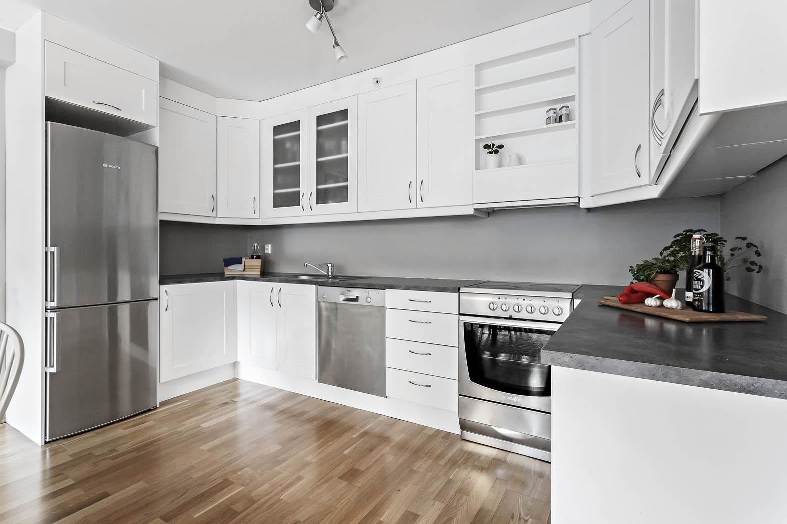 Praktisk kjøkken med hvit innredning og laminat benkeplate. God skapplass. Galleribilde