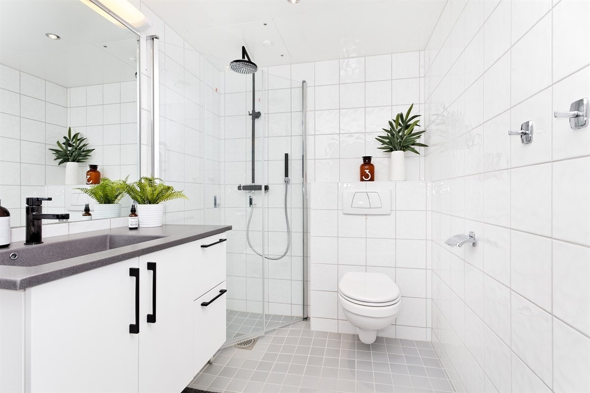 Delikat flislagt bad med opplegg for vaskemaskin og tørketrommel Galleribilde