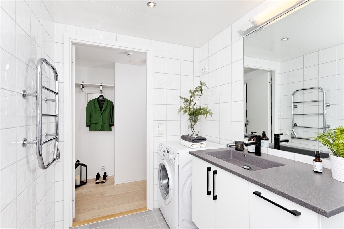 Delikat flislagt bad med opplegg for vaskemaskin og tørketrommel Galleribilde