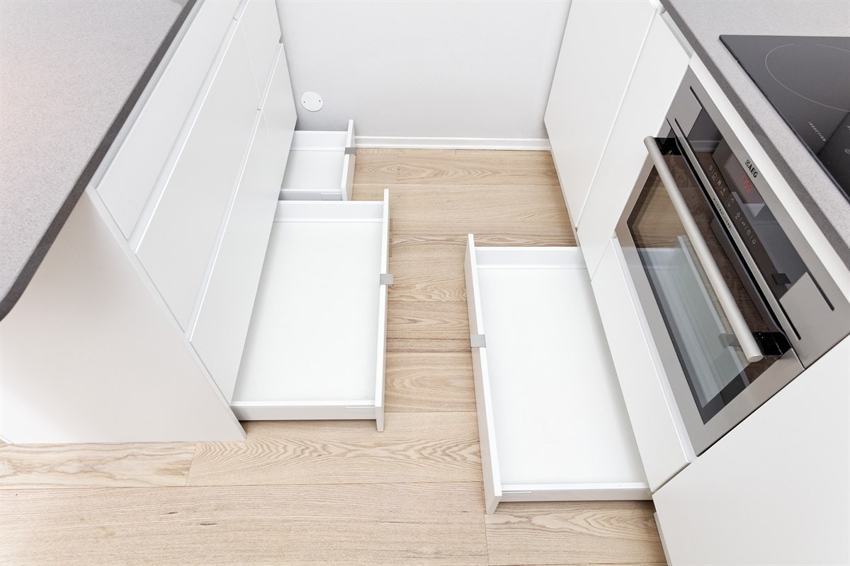 Skuffer og skap fra gulv til tak. Kjøkkeninnredningen er maksimalt utnyttet. Galleribilde