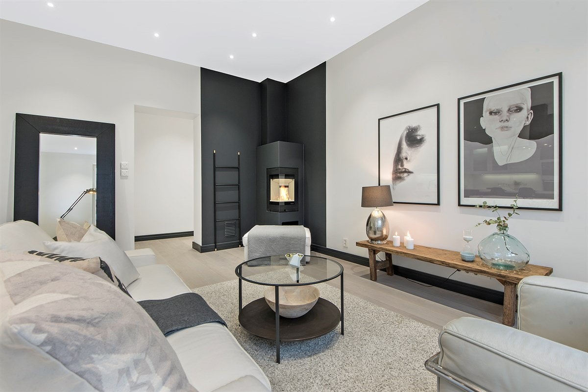 Stuen har en hyggelig peisovn og delikat fargevalg Galleribilde