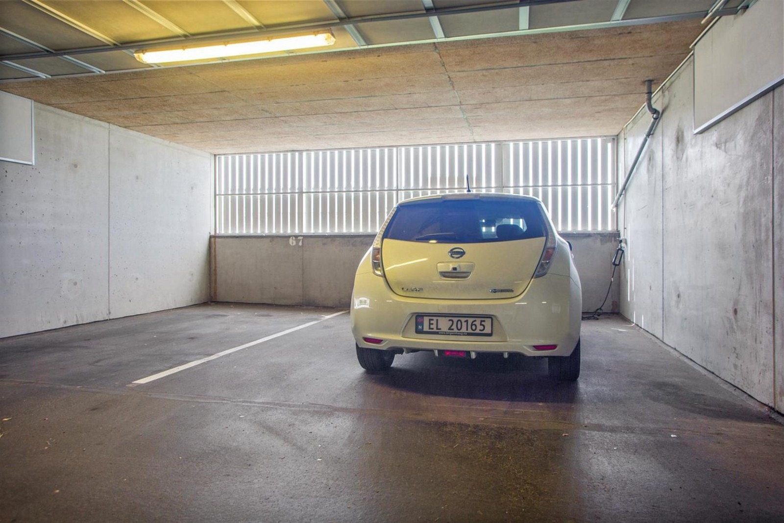 Den tilhørende parkeringsplassen i felles garasjeannlegg er stor og har lademuligheter for el-bil Galleribilde
