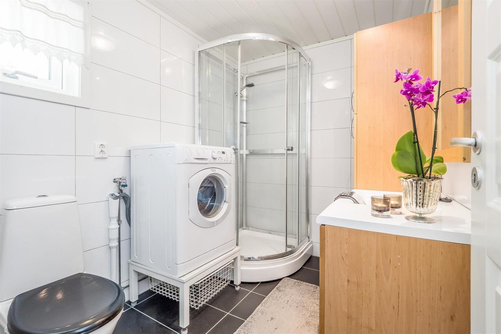 Funksjonelt bad med dusjkabinett og opplegg for vaskemaskin. Galleribilde
