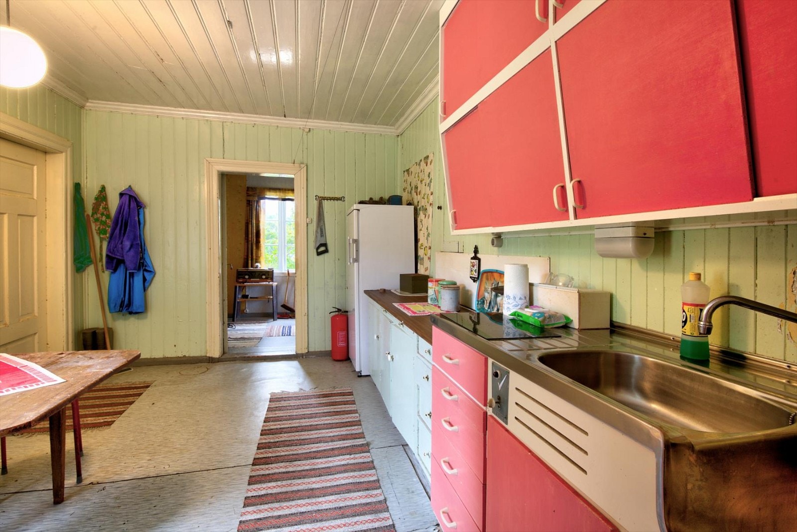 Oppvaskbenkseksjon med heldekkende oppvaskbenkbeslag og VV bereder plassert i benk. Overskap med malte finerte skyvedører. Galleribilde