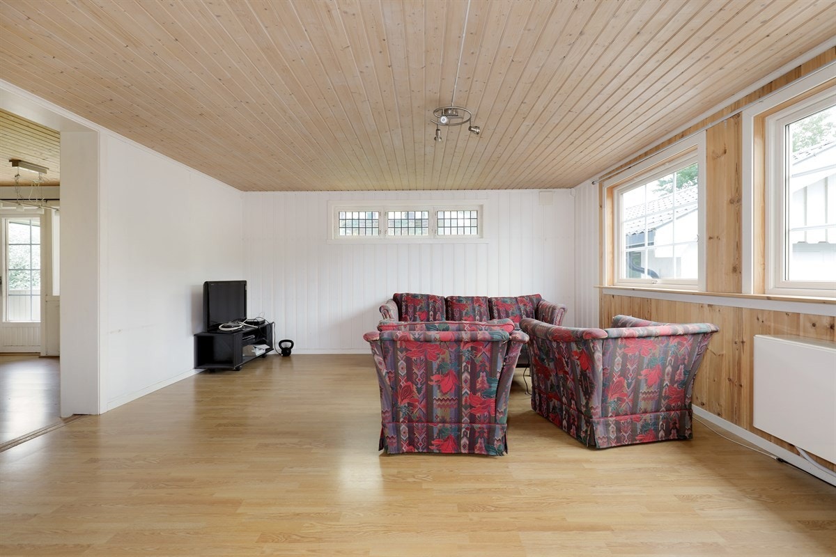 Stuen i første etasje er hyggelig med en god størrelse som gir rikelig med plass til sofaløsning med tilhørende møblement og andre komfortmøbler. Galleribilde